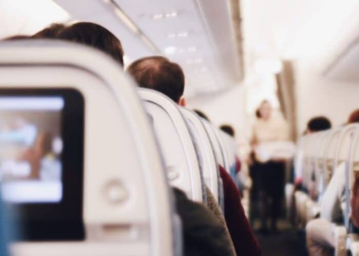 ext: Covid19 questions to ask your travel insurer before you buy a policy. A photo of the back of the seats on a plane.