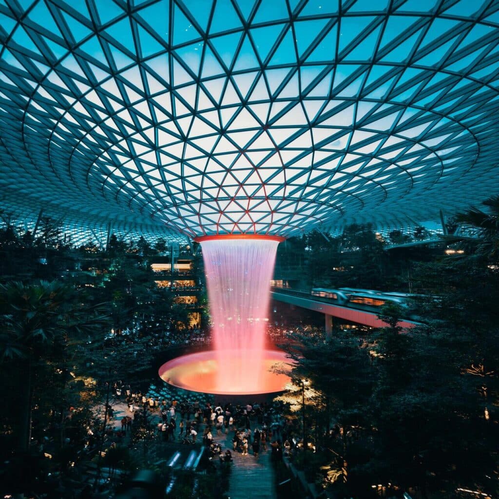 Beautiful fountain inside building, surrounded by people