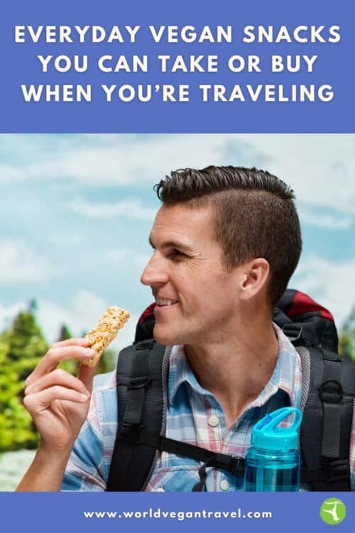 A man eating a protein bar with the text: Everyday VEgan Snacks you can take or buy when you're traveling world vegan travel.com