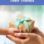 Hands exchanging a wrapped holiday gift with a blue ribbon – World Vegan Travel blog