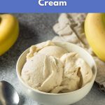 A bowl of creamy vegan banana ice cream made from frozen bananas, shown with spoons and fresh bananas.