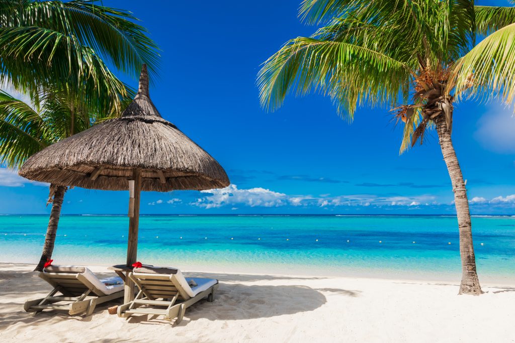 Chairs and umbrella at palm beach. Tropical holiday banner with ocean in Mauritius