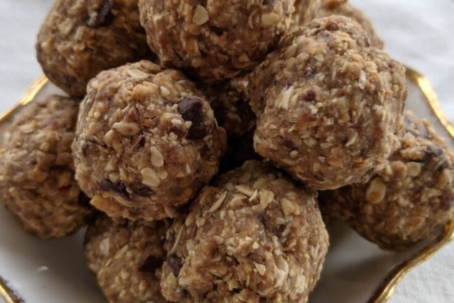 A close-up of homemade vegan power balls made with oats, dates, and nut butter on a small plate.
