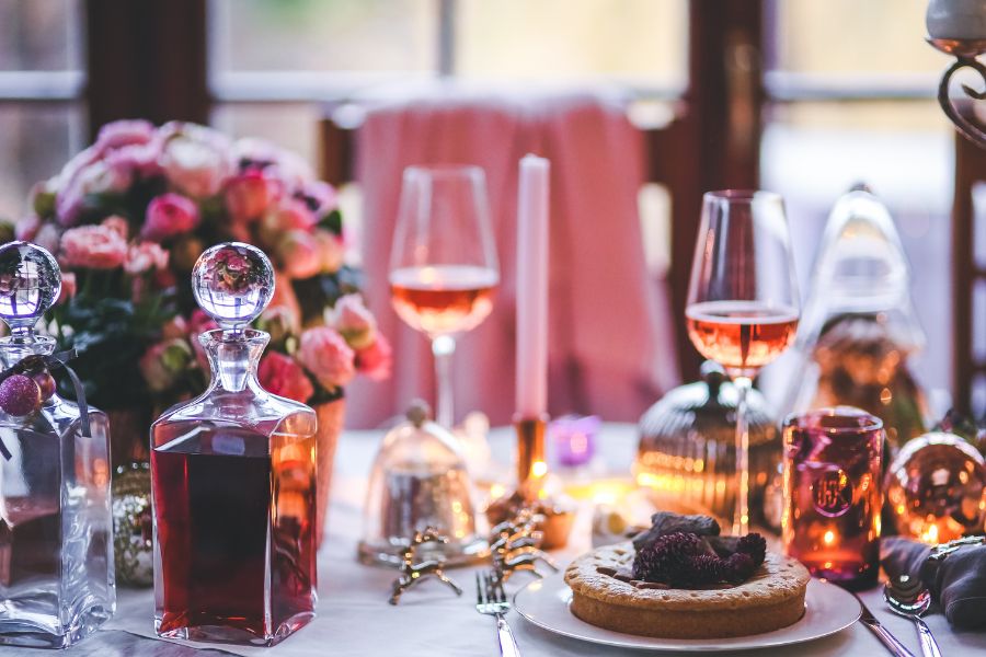 Elegant vegan holiday dinner table with candles, wine glasses, and festive decorations.