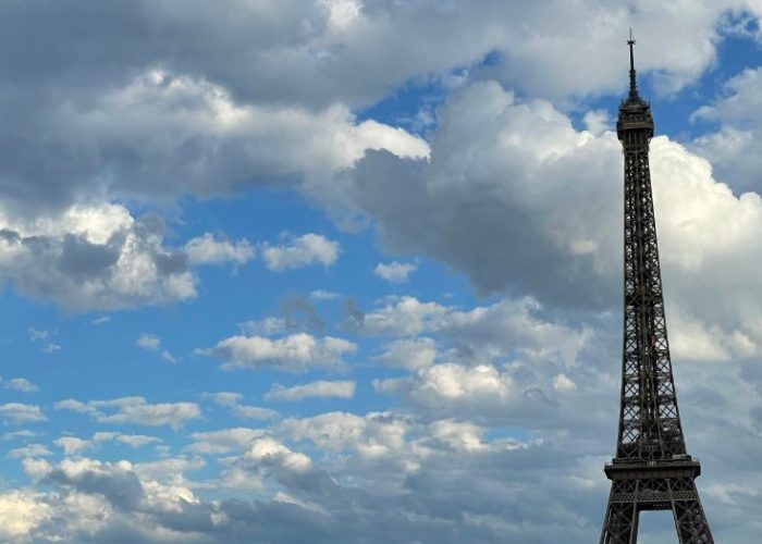 Eiffel Tower in Paris on a sunny day with tourists, a must-visit vegan-friendly destination
