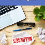 A laptop, plant, glasses, and a crumpled paper labeled “subscription,” showing the idea of choosing the best subscriptions to gift to vegans.