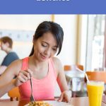 Woman enjoying a colourful vegan lunch with noodles and juice during a relaxing meal, part of World Vegan Travel’s vegan lunch guide.