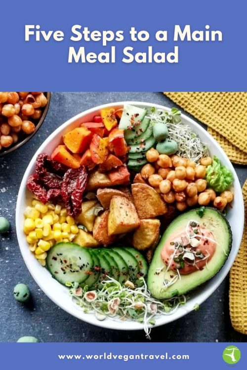 Colorful vegan salad bowl filled with veggies, potatoes, avocado and chickpeas, representing a healthy main-meal salad idea by World Vegan Travel.