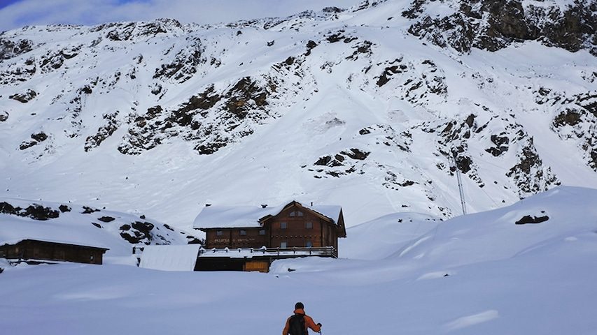 World Vegan Travel vegan hotels in Italy A ski tourer walking towards a mountain hut