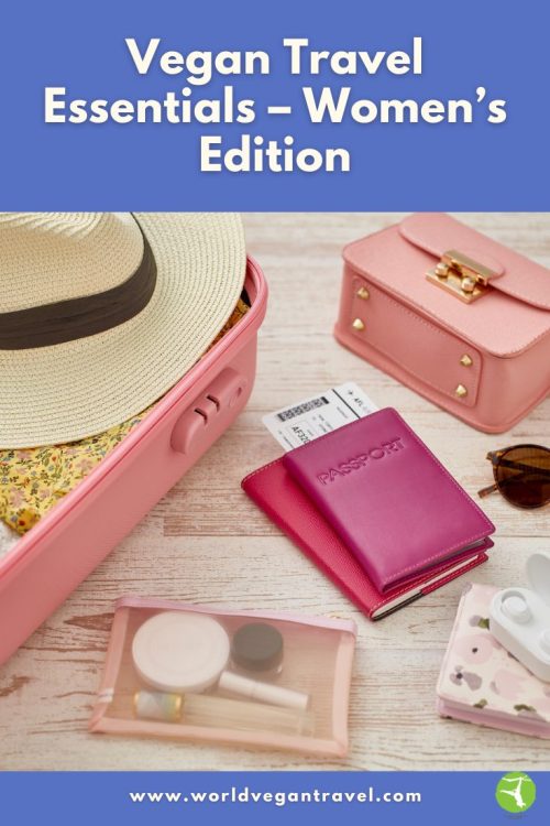 Flat lay of vegan-friendly travel essentials for women, including a pink suitcase, hat, passport, and toiletries.