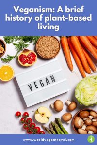 Fresh fruits, vegetables, grains, and a sign that says ‘Vegan’ displayed on a table representing the history of plant-based living.