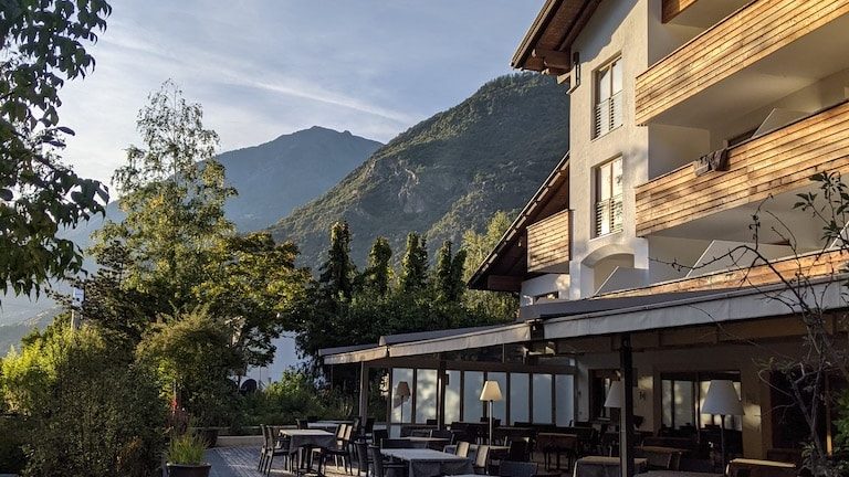World Vegan Travel vegan hotels in Italy The back patio of a modern mountain chalet in the late afternoon light