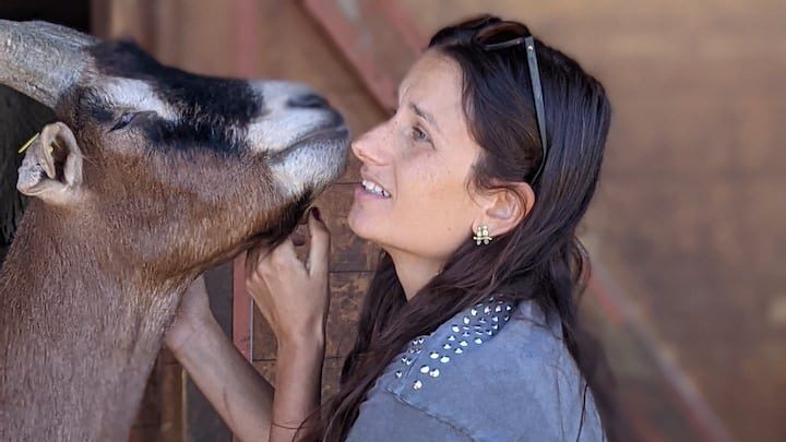 World Vegan Travel a young woman with goats