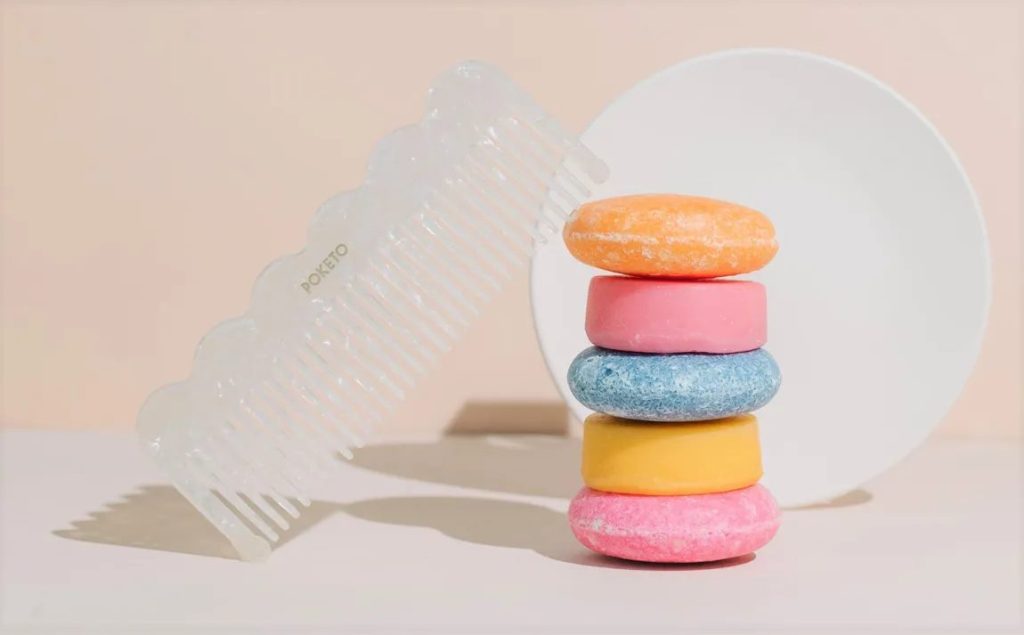 Colorful vegan zero-waste shampoo bars stacked with a comb – World Vegan Travel eco-friendly shampoo guide