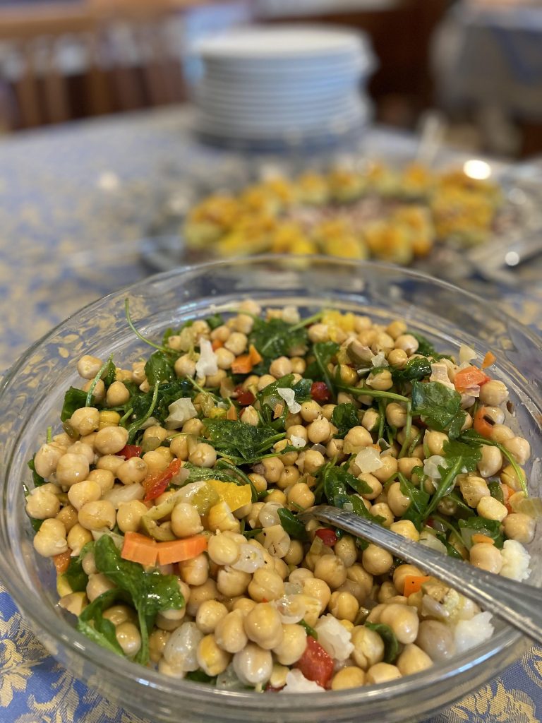 Chickpea salad with herbs and diced vegetables in a glass bowl