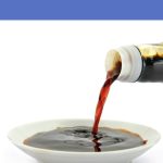 A bottle of fish sauce being poured into a small dish for a blog that explains vegan fish sauce options.