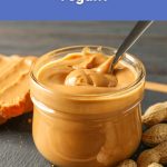 A jar of smooth peanut butter with a spoon inside, used for a blog post asking if peanut butter is vegan.