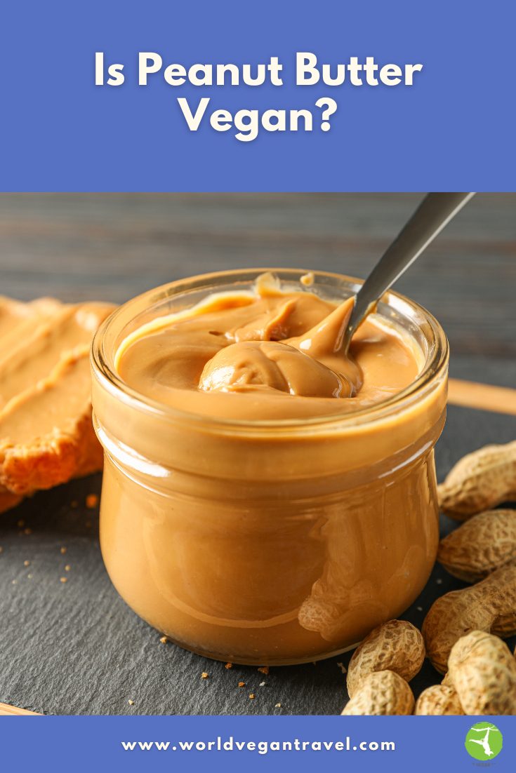 Is Peanut Butter Vegan – World Vegan Travel A jar of smooth peanut butter with a spoon inside, used for a blog post asking if peanut butter is vegan.