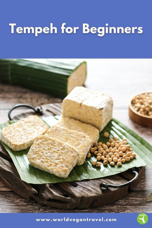 Fresh slices of tempeh on a banana leaf board, ready to cook, for the Tempeh for Beginners guide on World Vegan Travel.
