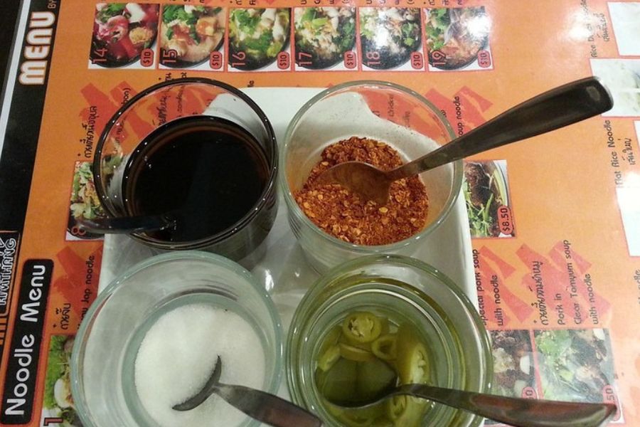 Small jars of Thai condiments on a restaurant table