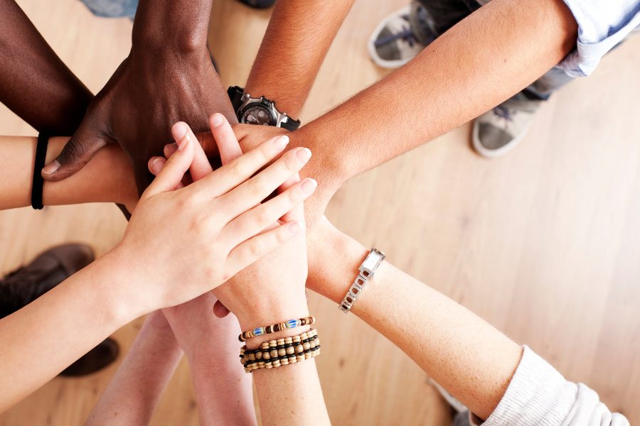 Diverse group of people joining hands in unity.