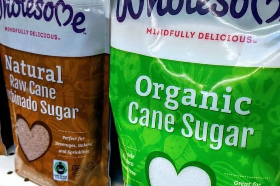 Bags of natural raw cane sugar and organic cane sugar on a grocery store shelf.
