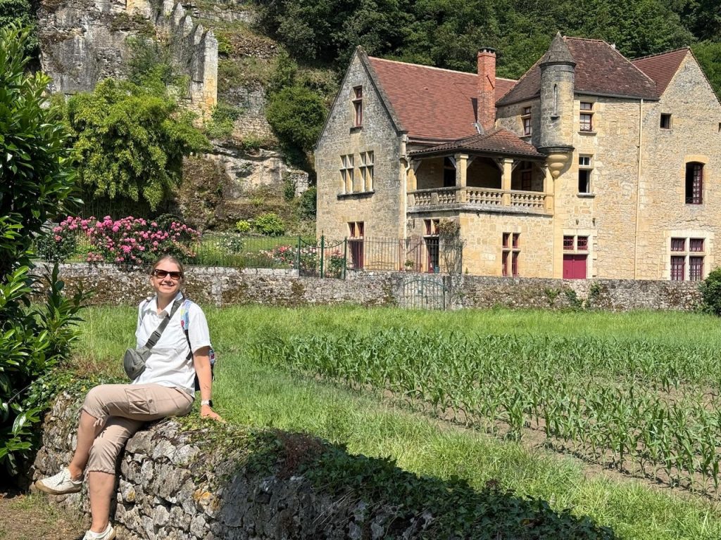 Woman smiling in front of a French chateau with gardens