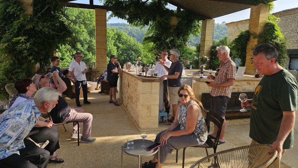 Group of travelers enjoying drinks together at sunset in a villa