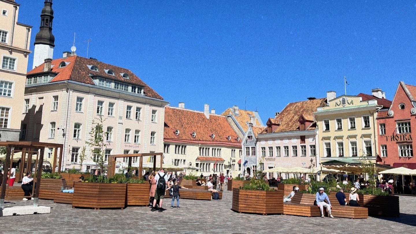 Colorful houses and people in Tallinn Old Town square.