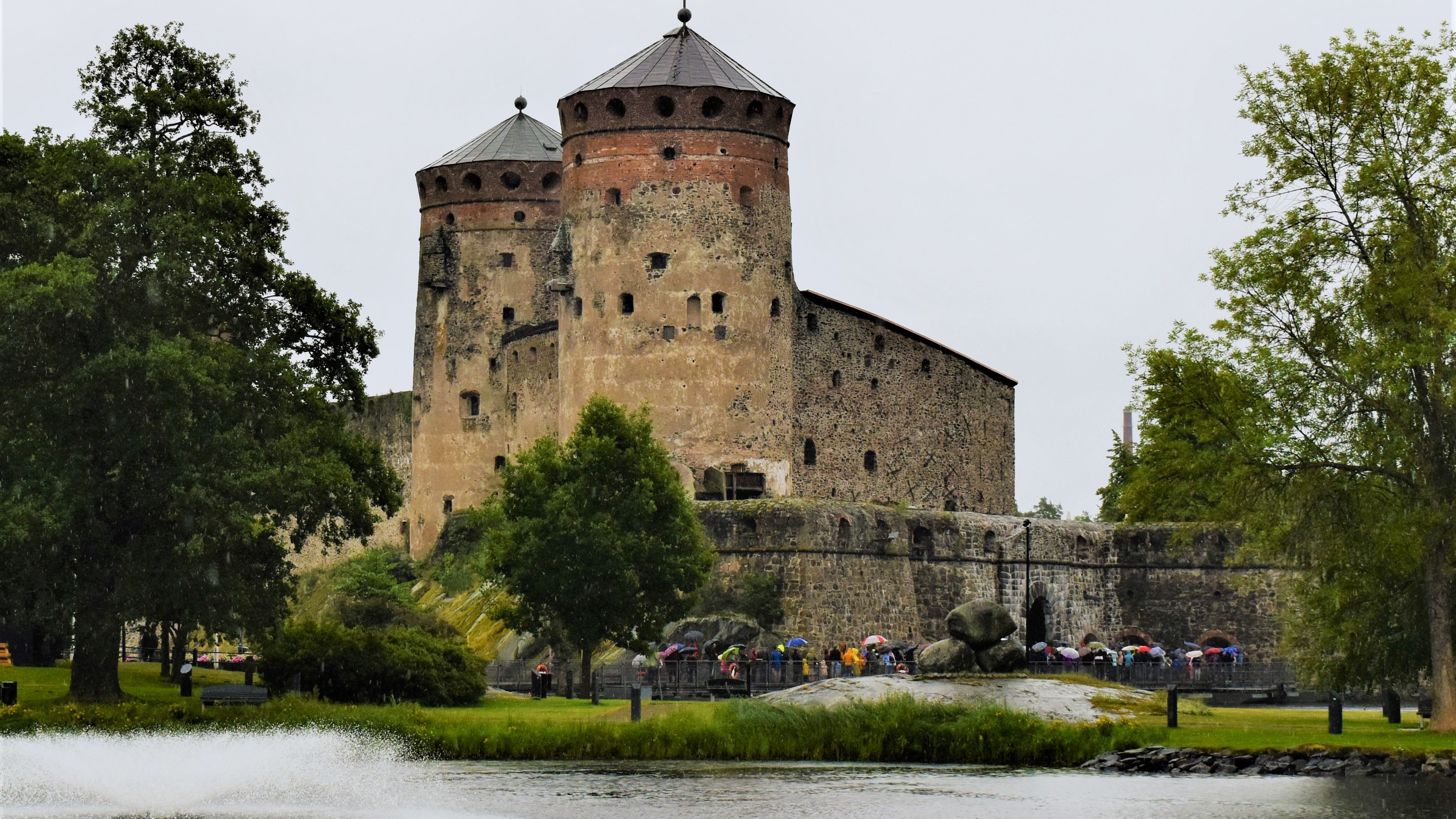 Old stone castle with two towers by the water in Finland.