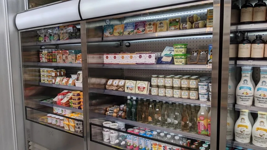 Vegan grocery fridge in Squamish stocked with plant-based milk, cheese, and snacks.