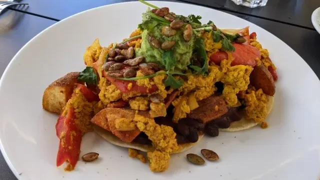 Squamish vegan breakfast with tofu scramble, potatoes, avocado, and fresh toppings.