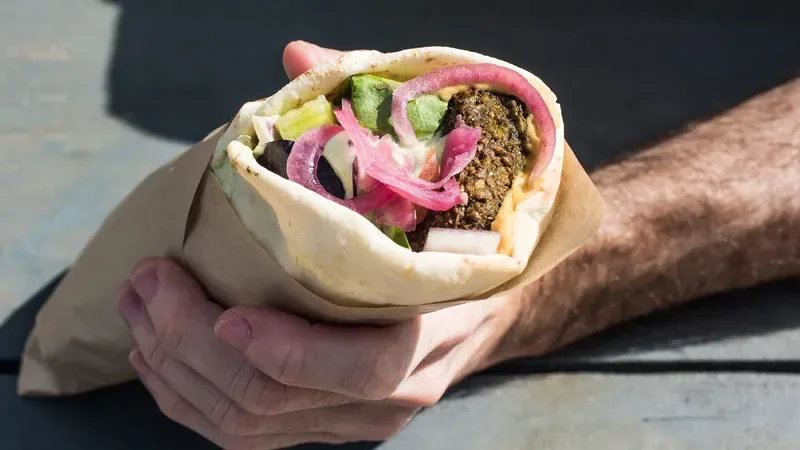 Squamish vegan wrap filled with falafel, pickled onions, and fresh vegetables.