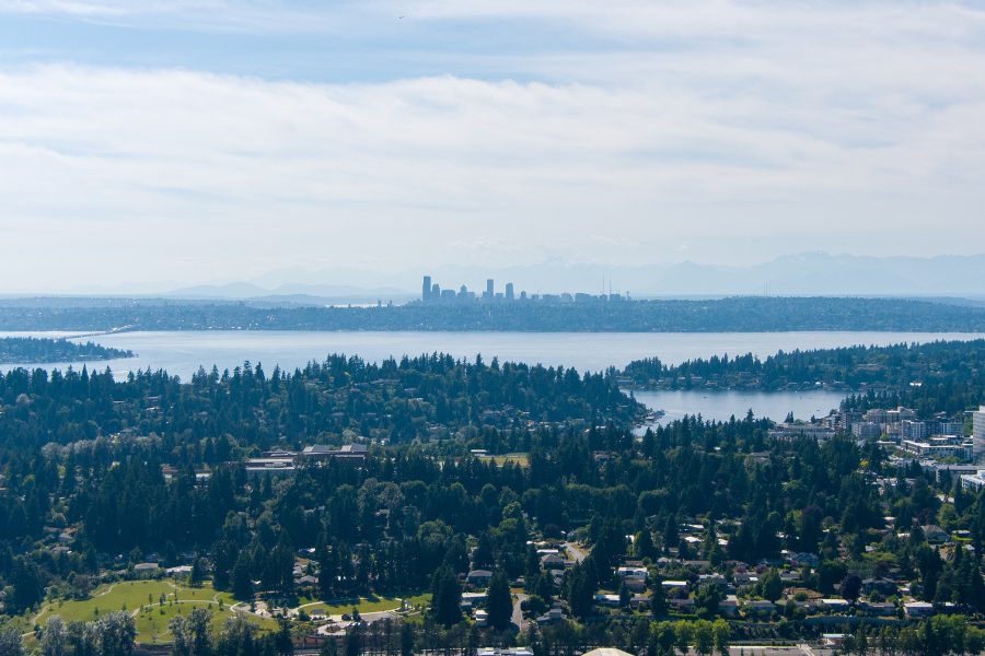 Seattle city skyline with water, trees, and mountains in the distance