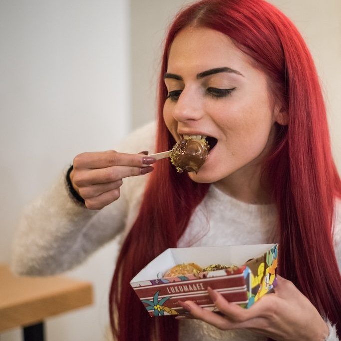 Person eating a vegan dessert on a stick
