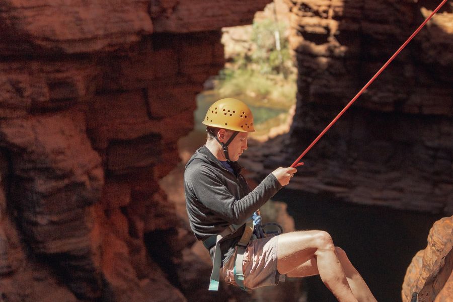 Person abseiling down a canyon in Karijini National Park Western Australia