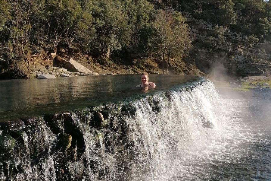 Benje thermal springs in Albania with stone bridge and clear blue water during a peaceful road trip