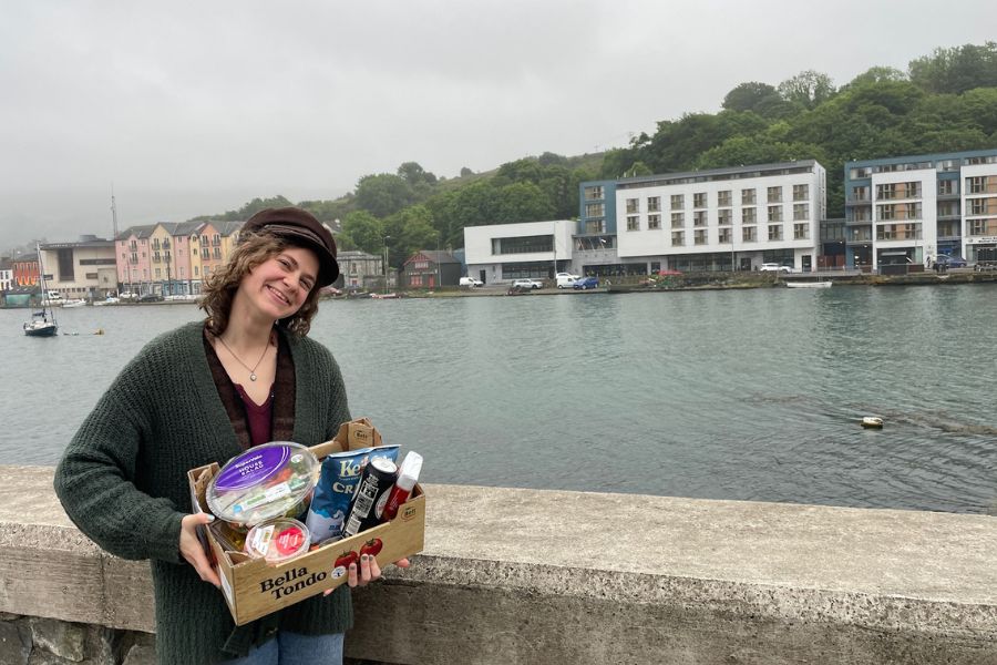 Kiara holding vegan food during a solo travel adventure by the water