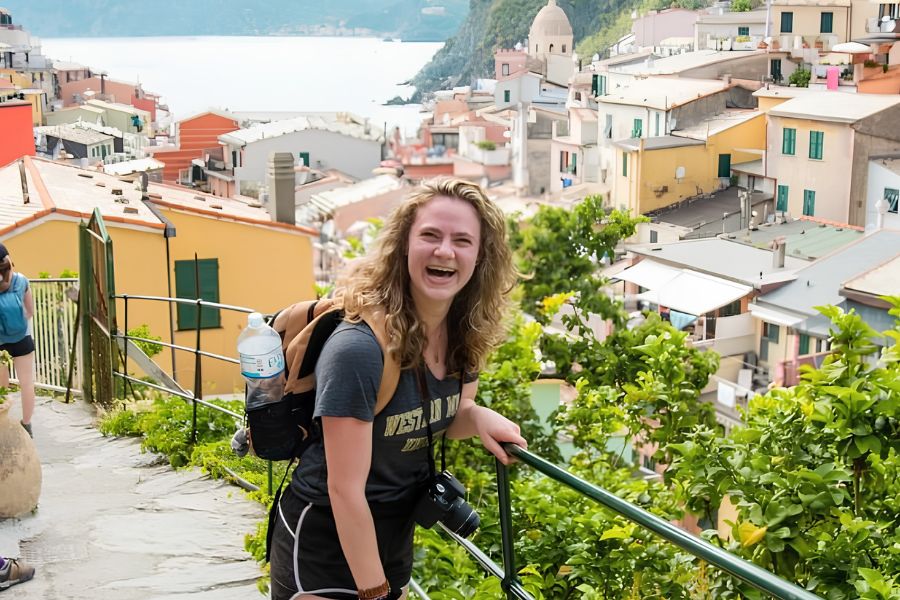 Kiara smiling while exploring a colorful coastal town on a travel adventure