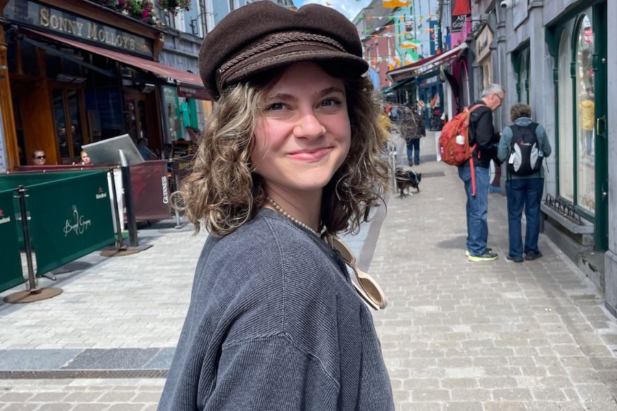 Kiara smiling on a city street during a vegan travel adventure