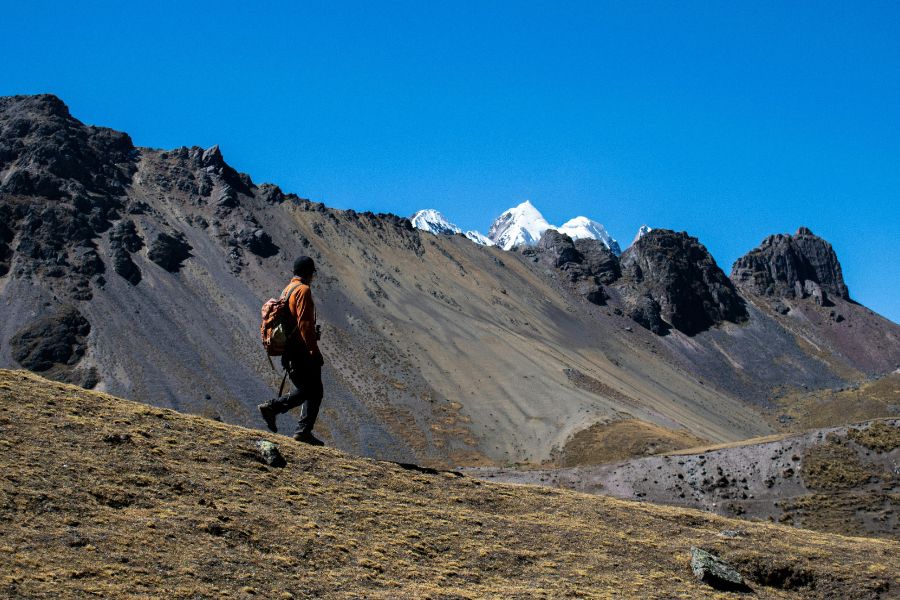 A male walking through the mountains in Peru during his vegan travel journey.