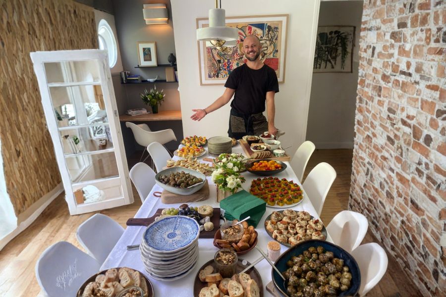Ben Riddle standing behind a table filled with vegan food.