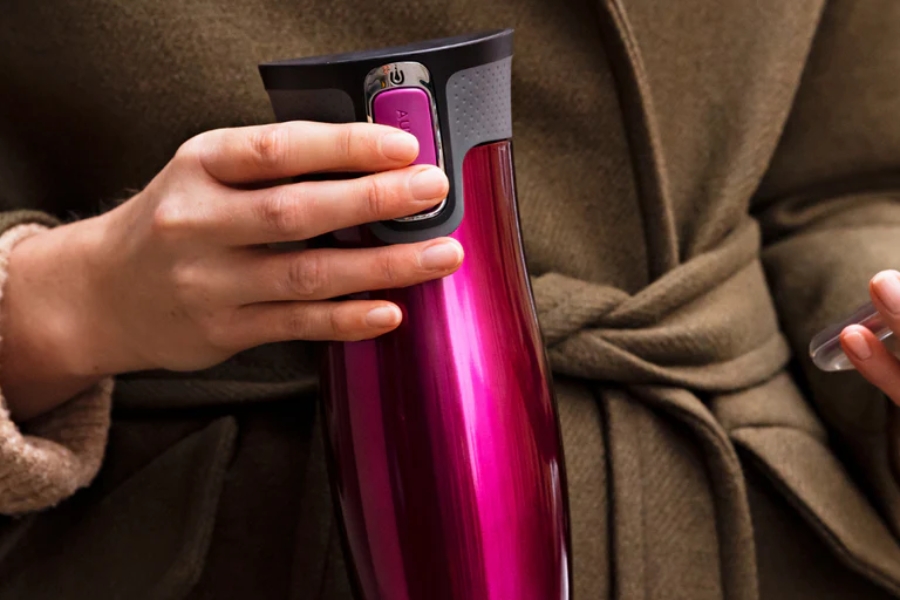 Contigo insulated travel coffee mug held by a traveler.