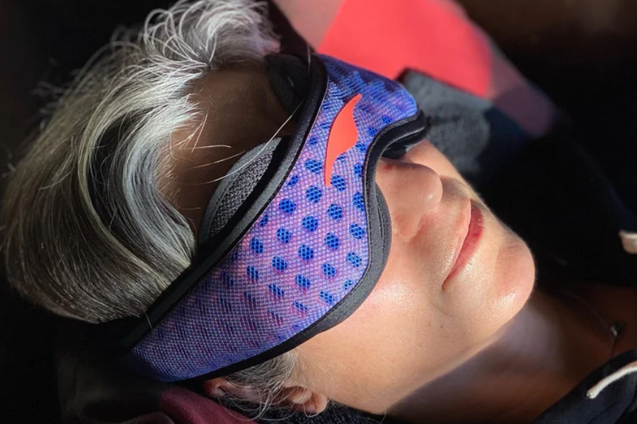 Traveler wearing a Manta Sleep mask, one of the smart travel essentials for better rest on trips.