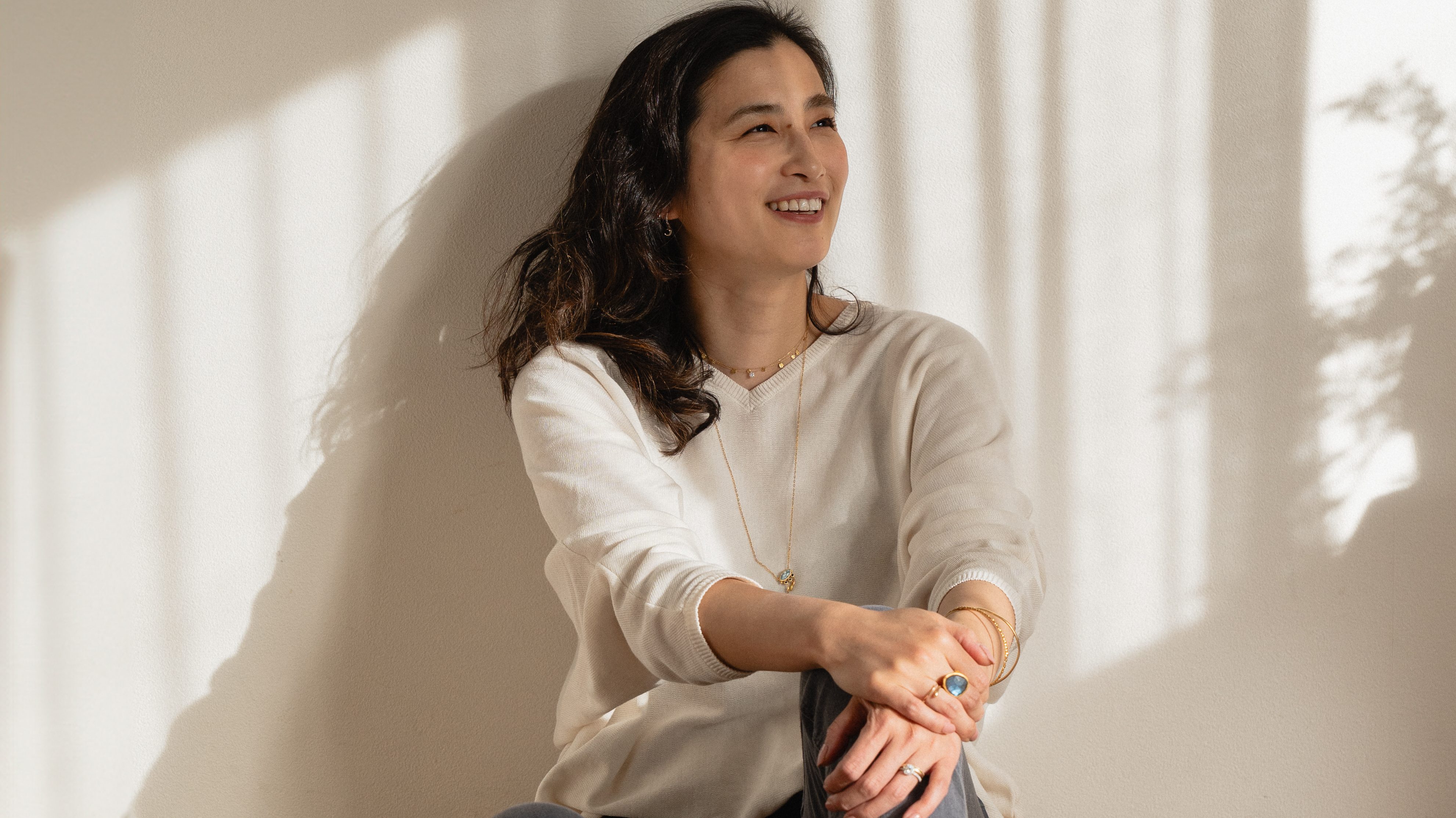 A female sitting against a lounge wall