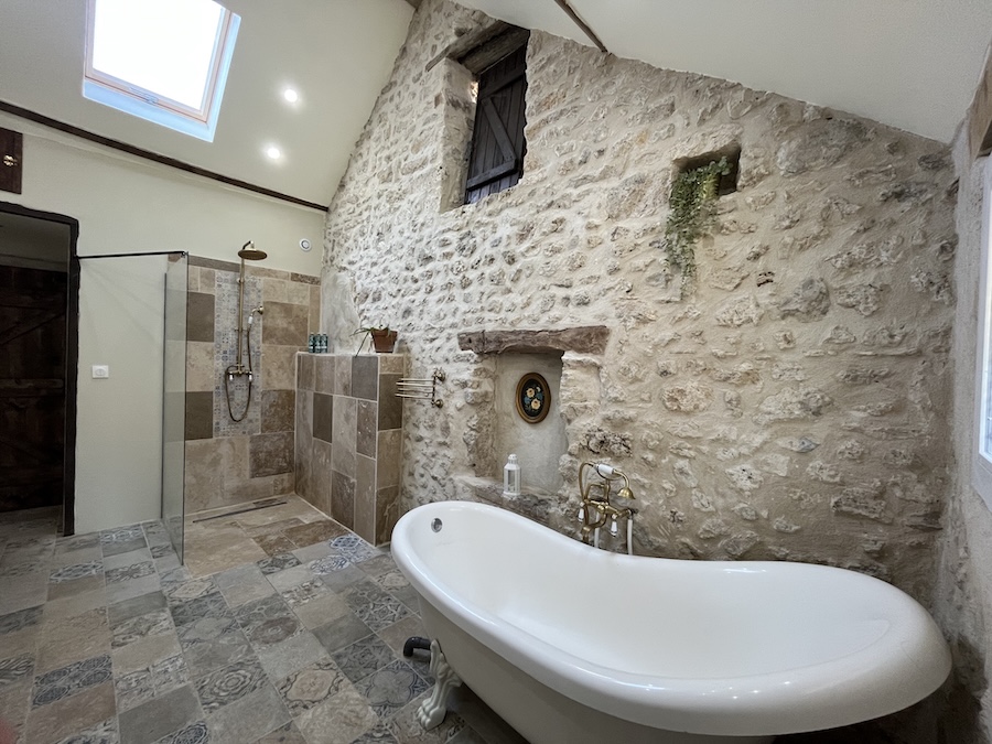 Rustic bathroom with clawfoot bathtub in Bella’s Cottage at La Grange DesRochers