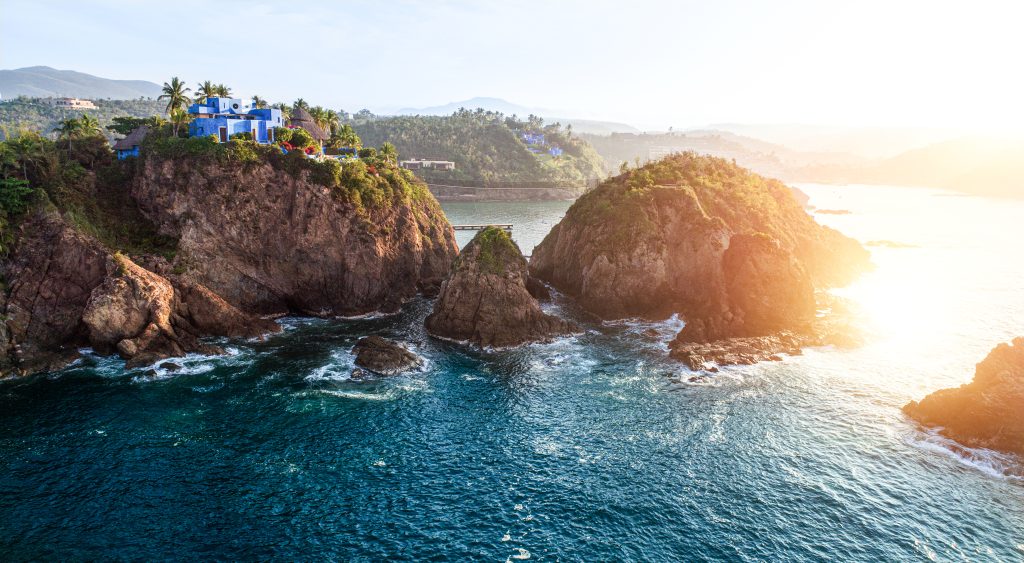 Rocky Careyes shoreline and coastal villas glowing at sunset in Mexico