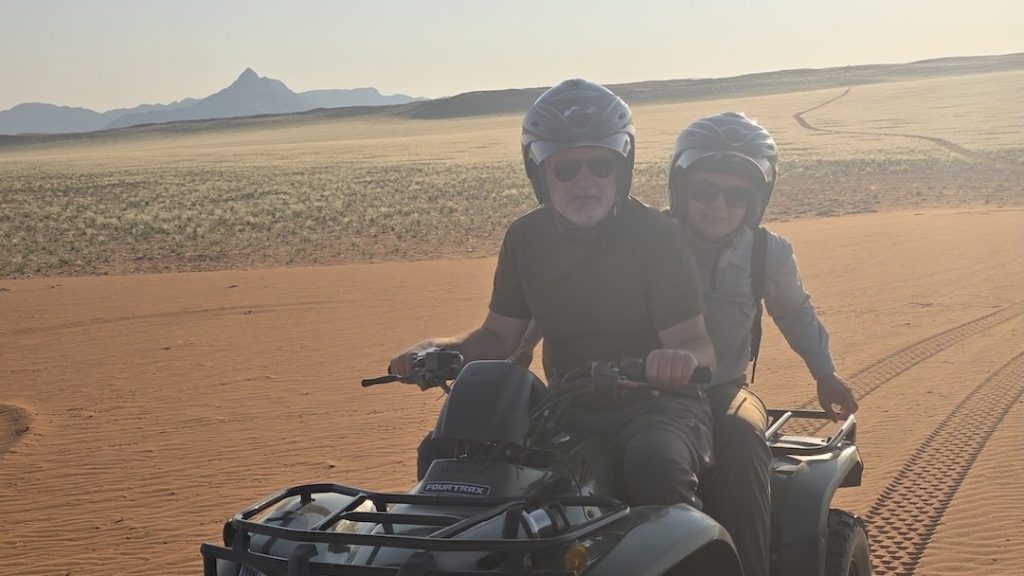 Brighde and Seb quad biking across the red dunes in Namibia