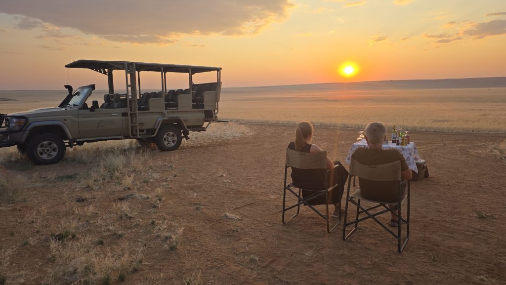 Brighde and Seb enjoying sunset drinks at Kwessi Dunes in NamibRand